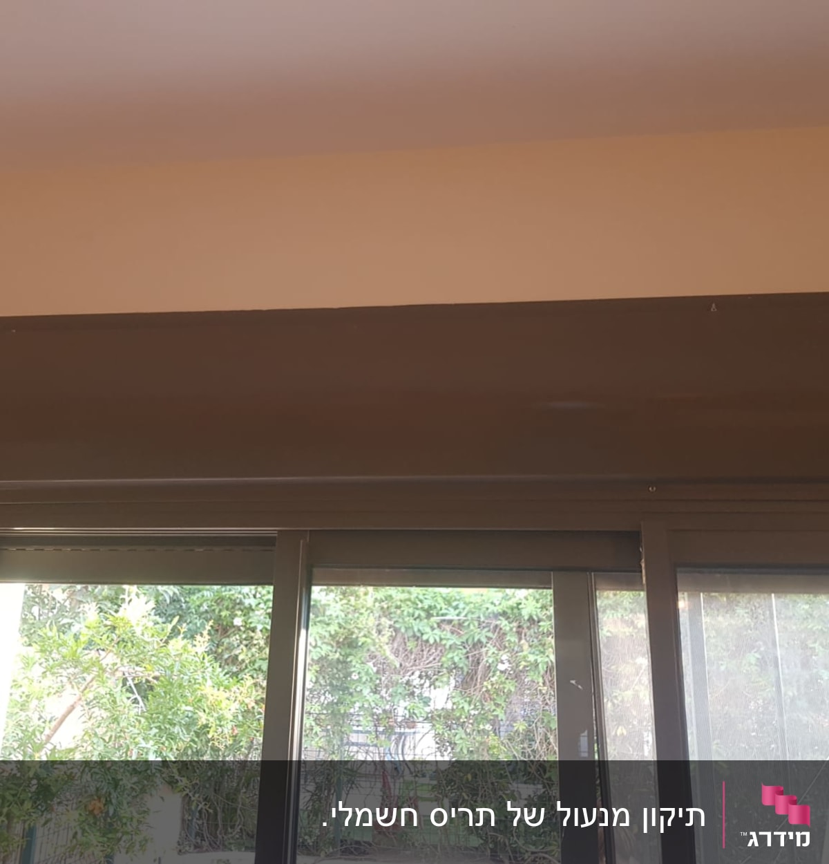 תריסים סגורים עם קופסת תריס חומה מעל החלון